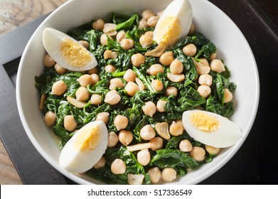 Boiled Spinach Salad With Chickpeas And Hard Boiled Egg In A White Bowl Overhead Shot