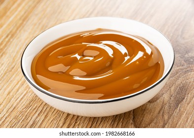 Boiled Sweet Condensed Milk In White Bowl On Wooden Table