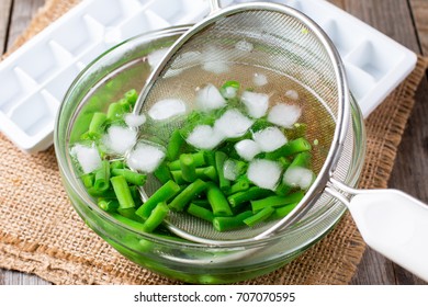 Boiled vegetables, green beans  in ice water after blanching - Shutterstock ID 707070595