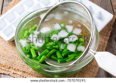 Boiled vegetables, green beans  in ice water after blanching