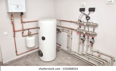 The boiler room with a lot of different equipment as a boiler, heater,pipes, expansion tank and other