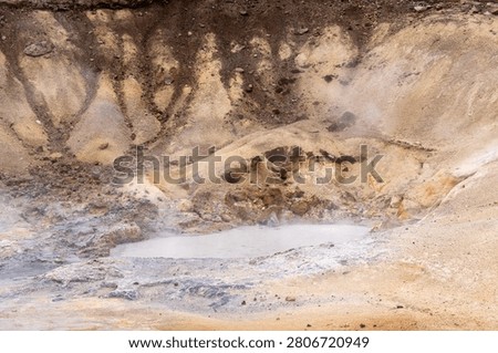 Boiling grey mud pool and steaming mineral soil in the Seltún geothermal area, Iceland