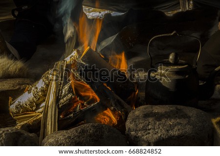 Boiling the kettle to make coffee over an open fire in a teepee in Sweden