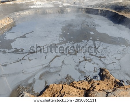 Boiling mud pot pit with grey bubbling volcanic mud and steam in Hverir geothermal region Iceland