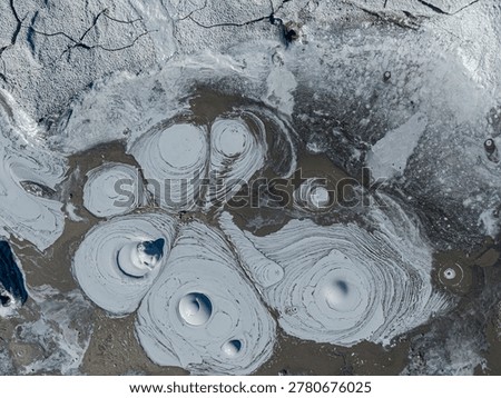 Boiling mud pots creating abstract patterns and textures in the geothermal landscape of hverir, iceland