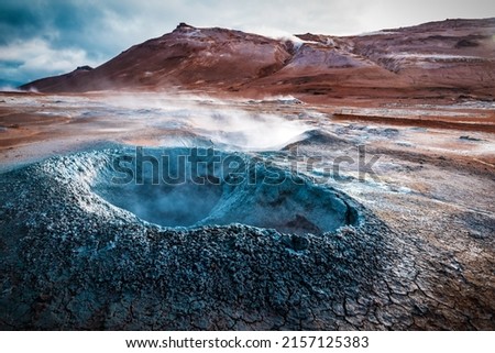 Boiling mudpots in the geothermal area Hverir and cracked ground around. Iceland landscape. Iceland. Europe