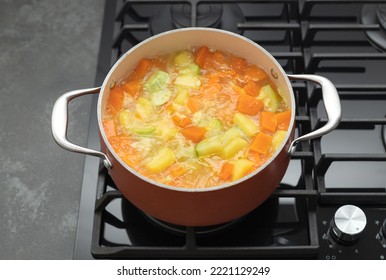 Boiling Pot Of Pumpkin Soup On Gas Stove Top. Clean Eating, Vegan Food Concept. Top View