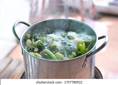 A Boiling Pot Of Vegetable Soup On Top Of The Stove.