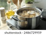 Boiling potatoes in pot on stove in kitchen