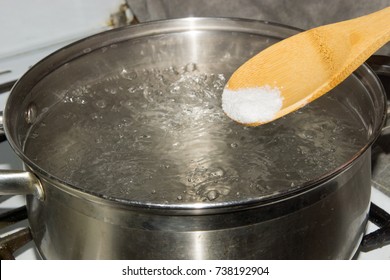 In Boiling Water Pour Salt With A Wooden Spoon.