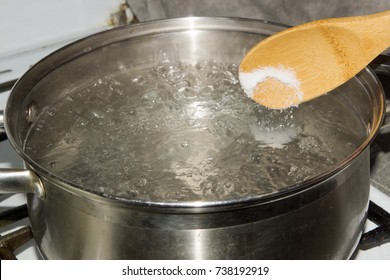 In Boiling Water Pour Salt With A Wooden Spoon.