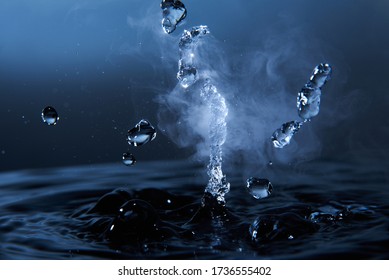 Boiling Water Splash With Steam On Dark Blue Background Closeup.