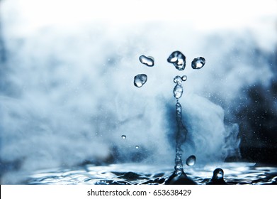 Boiling water splash with steam on black background closeup - Shutterstock ID 653638429