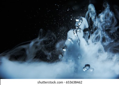 Boiling water splash with steam on black background closeup - Shutterstock ID 653638462