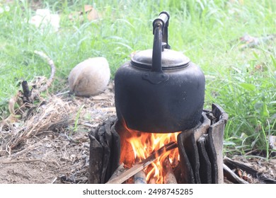 Boiling water with a steel kettle blackened by soot, on a firewood stove in a hut at the edge of a farm. - Powered by Shutterstock