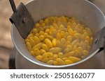 Boiling yellow silkworm cocoons by boiler to make silk thread.