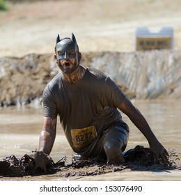 BOISE, IDAHO/USA - AUGUST 10: Man 8272 Wearing A Batman Mask Splashes Mud At The Finish Line. This Race Took Place At The The Dirty Dash In Boise, Idaho On August 10, 2013 