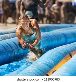 BOISE, IDAHO/USA - AUGUST 25:Unidentified woman jumps to go down the slide. The Dirty dash is a 10k run through obstacles and mud on August 25, 2012 in Boise, Idaho