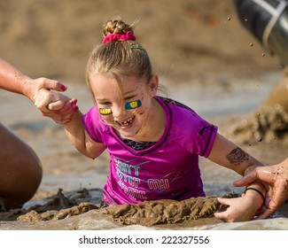 BOISE, IDAHO/USA - AUGUST 8, 2014: Unidentified Young Kid Being Helped Through The Mud Pit At The Dirty Dash In Boise, Idaho