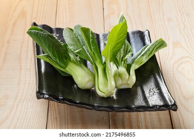 Bok Choy (Chinese Cabbage) In Black Plate On Wooden Background.
