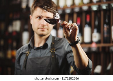 Bokal of red wine on background, male sommelier appreciating drink - Shutterstock ID 1178282386