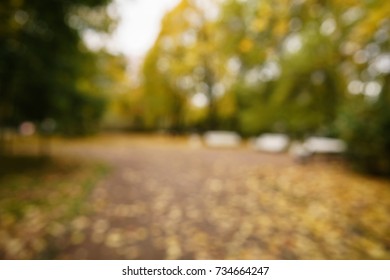 Bokeh Background Of Autumn Town With Golden Fall Trees And Fallen Leaves