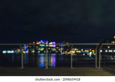Bokeh background of Boston Harbor at night. Blurred city lights in the distance