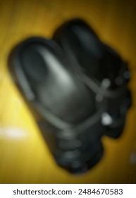 Bokeh, blur. Basic pair of open toe slide sandals for men, women and children. Black slippers instead of flip-flops