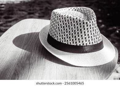 Bokeh. A fedora hat made of woven rattan on a wooden table. Photographed in black and white style. - Powered by Shutterstock