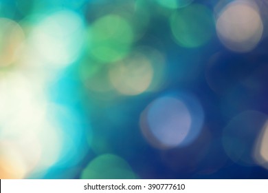 Bokeh In Green And Blue With Flares Background. Defocused Colorful Lights.