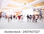 Bokeh light in event or conference hall background with blurry visitors concept. Crowd of anonymous abstract blurred and defocused people at airport, trade fair, convention or trade show exhibition.