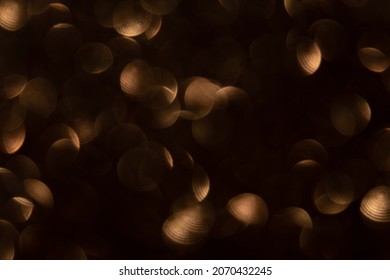 Bokeh light overlay. Circle pattern. Optical lens flare. Flash leak effect. Defocused brown round spot texture glow on blur dark night abstract background.