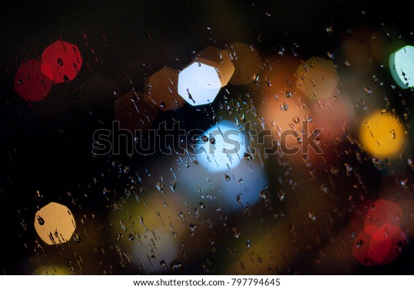 Bokeh and\
light at a rainy night through a\
window
