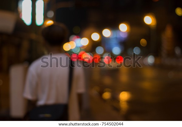 Bokeh at night, the man stands on the street\
blurred background.