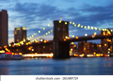 Bokeh Photo Of New York City Brooklyn Bridge With Downtown Skyline Over East River At Night 