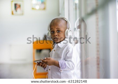 A bold boy listening to music at home