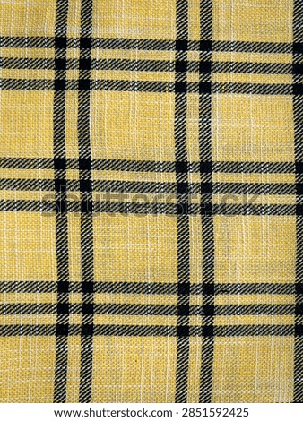 A bold, high-contrast textile pattern featuring vibrant yellow fabric intersected by clean black grid lines and plaid stripes. Ideal for fashion apparel, statement lifestyle designs, and energetic background mockups