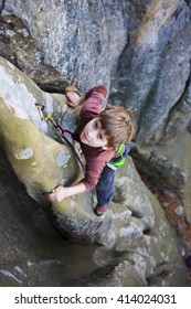 Bold Kid Rock Climber Climbs On A Difficult Wall.
