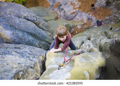 Bold Kid Rock Climber Climbs On A Difficult Wall.