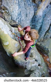 Bold Kid Rock Climber Climbs On A Difficult Wall.