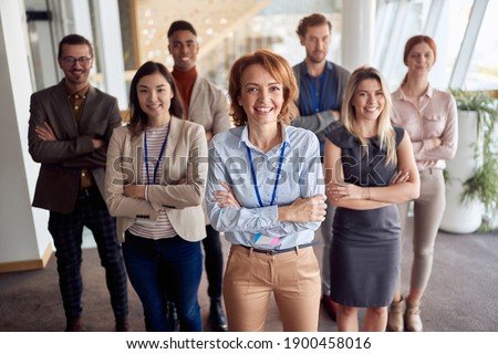 bold and outgoing group of successful business people, looking at camera with team leader in front . eye contact, looking at camera, smiling