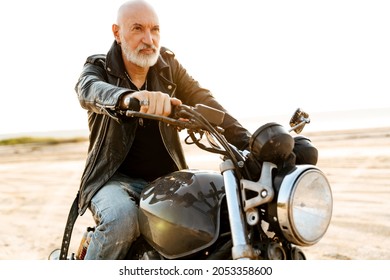 Bold Senior Man Wearing Leather Jacket Riding Motorcycle Outdoors On Summer Day