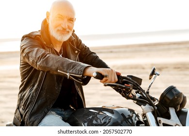 Bold Senior Man Wearing Leather Jacket Riding Motorcycle Outdoors On Summer Day