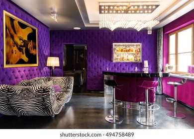 Bold Violet And Pink Colours In The Room With Striped Couch