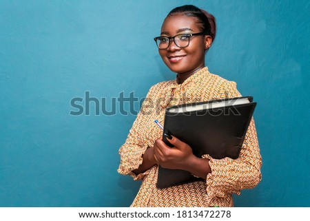 Similar – Image, Stock Photo Portrait of young bold African American female in long zipper coat confidently looking at camera standing on orange background