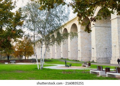 Boleslawiec, Poland - November 10, 2019: Park with benches and green grass in Boleslawiec, Poland next to the rail viaduct. The railway bridge is one of the longest bridges of this type in Europe