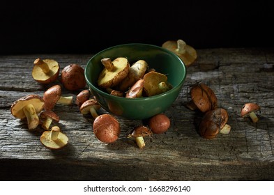 Boletus Mushrooms Spilled Out On Old Rustic Wooden Background, Backlit, Closeup, Copy Space, Go To The Forest Mushrooming Or Organic Vegetarian Food Concept