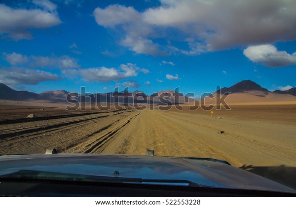 Bolivia, dramatic landscape\
of desert and mountain seen from the jeep driving to chile in a\
road trip starting from salr de uyuni towards atacama desert in san\
pedro
