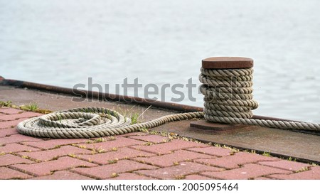 Bollard and mooring rope from a moored ship on the Mittellandkanal near Magdeburg in Germany                              