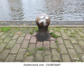 a bollard with a sad face near a canal in Amsterdam